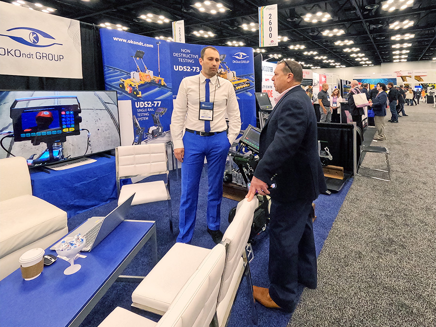 OKOndt GROUP specialist consulting a visitor at the company booth at Railway Interchange 2025, Indianapolis